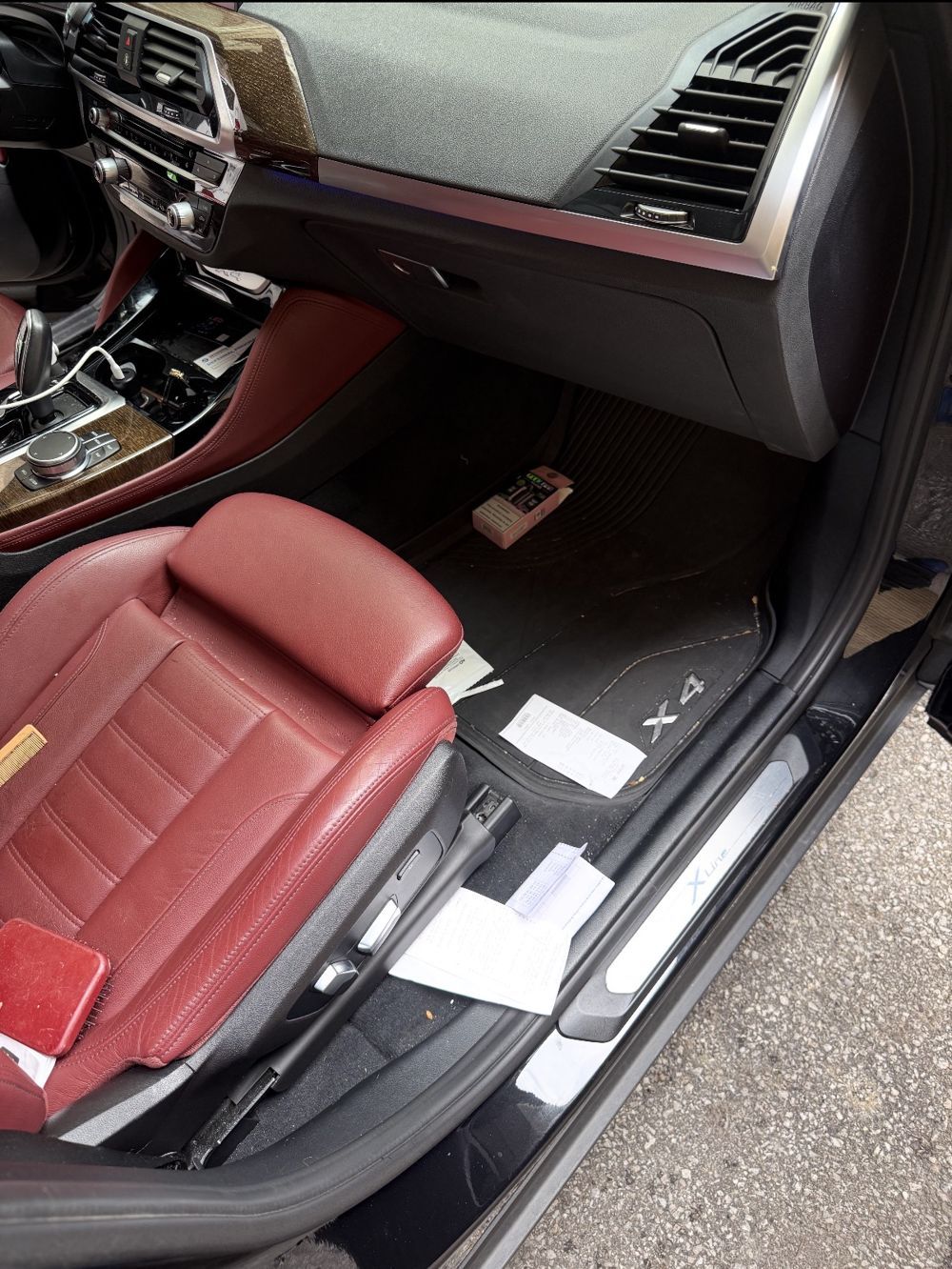 BMW X4 passenger footwell with trash and debris